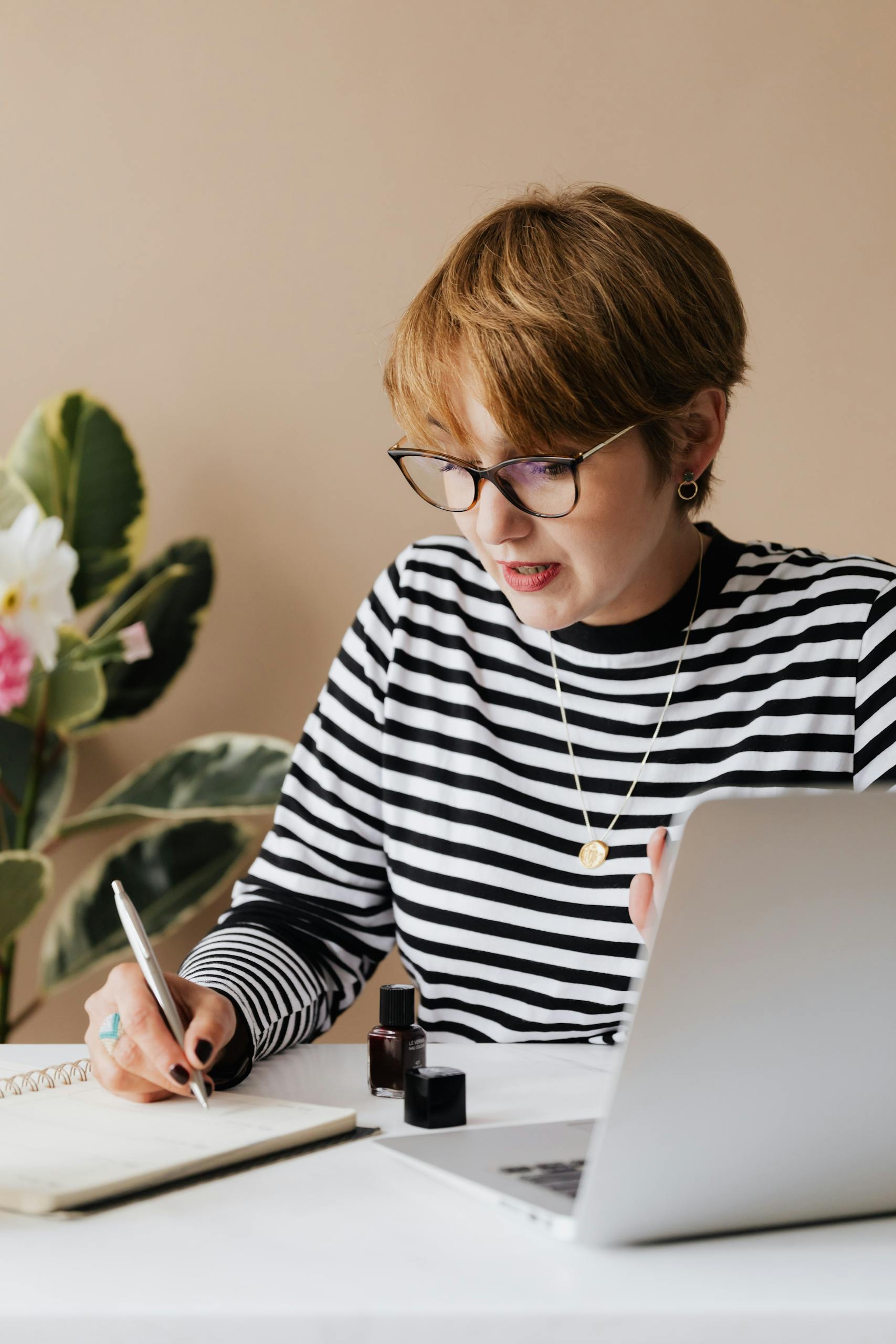Focused woman writing notes in notebook