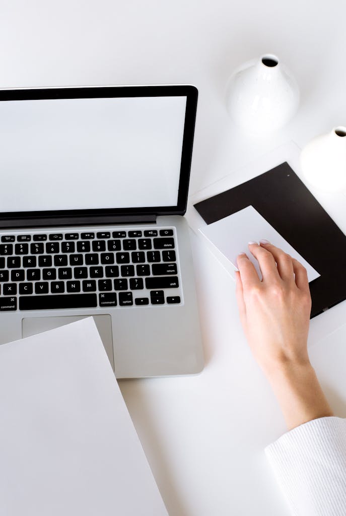 Person Using Macbook Pro on White Table