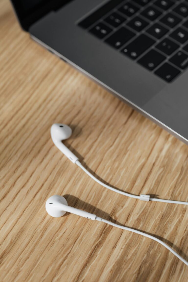 Earphones near laptop on wooden table